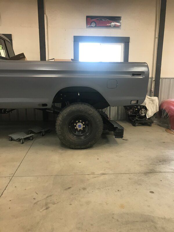 A truck is sitting on a lift in a garage.