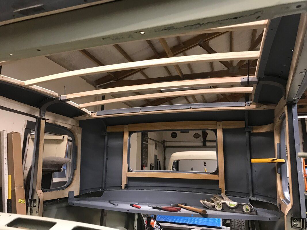 A camper van is being built in a garage.