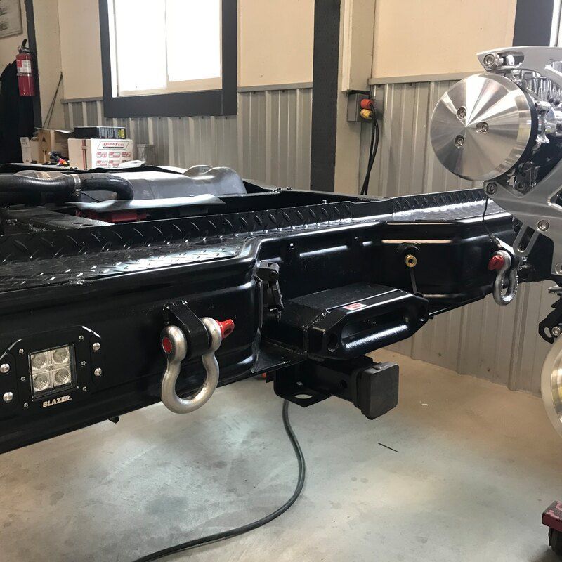 A black truck with a tow hook attached to it