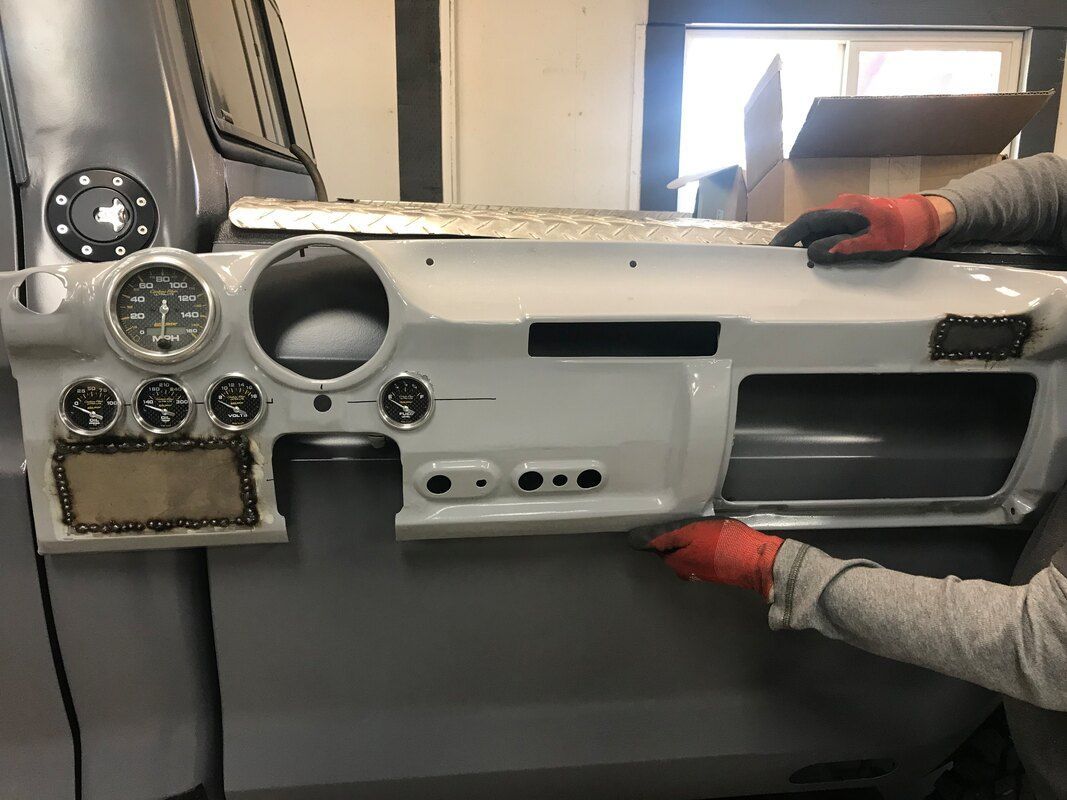 A person is working on a dashboard on a truck.