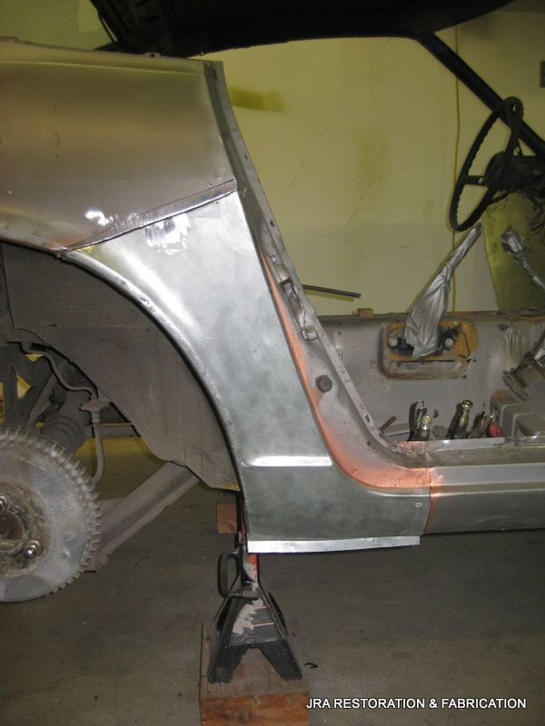 A car is sitting on a wooden stand in a garage ..