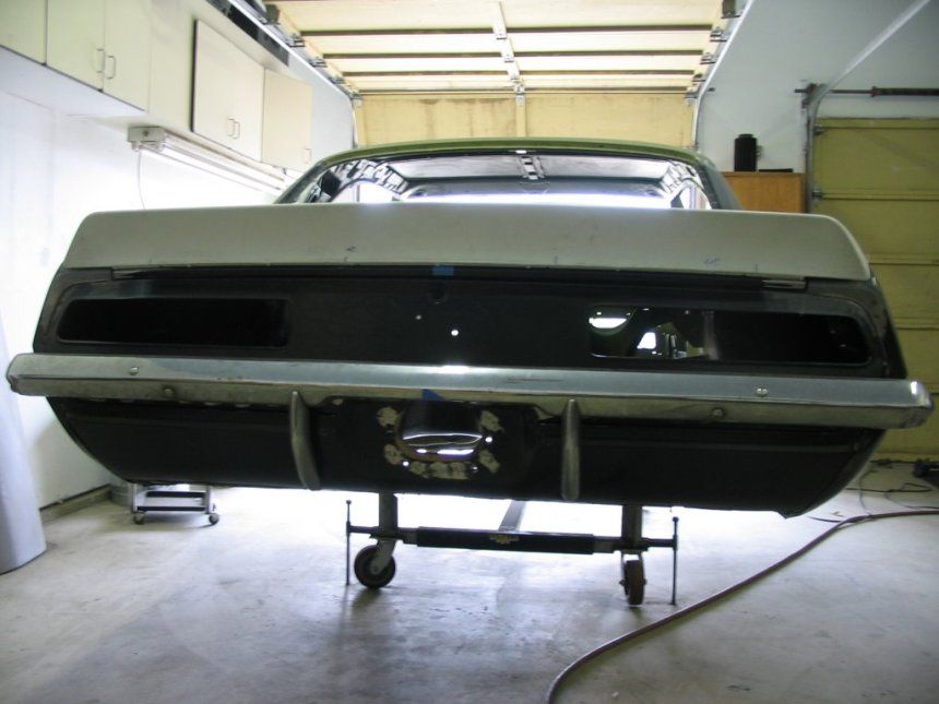 A black car is sitting on a cart in a garage