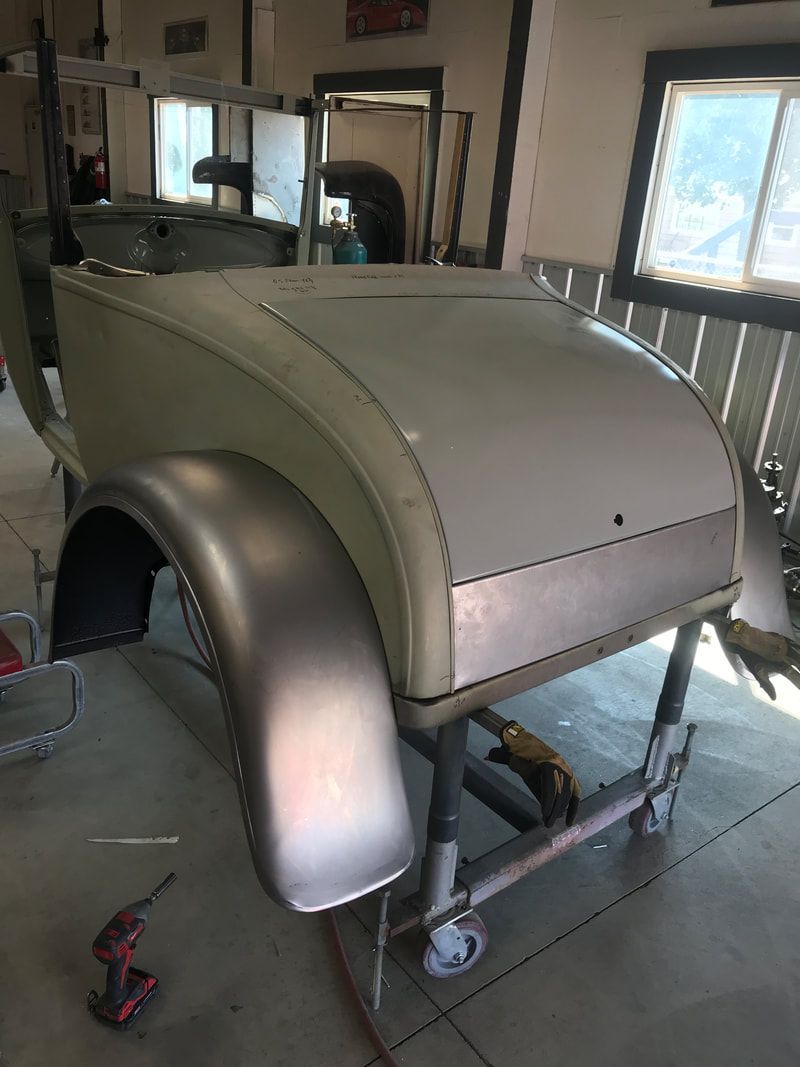 A car is sitting on a cart in a garage.