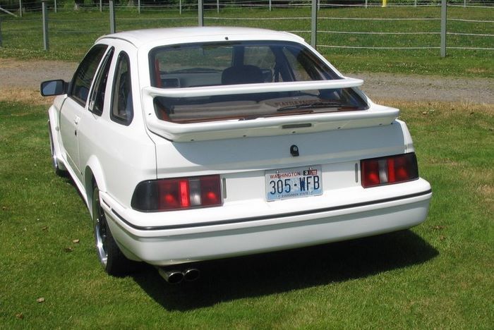 A white car with a license plate that says 305-mfb