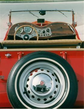 A red car with a spare tire on the back