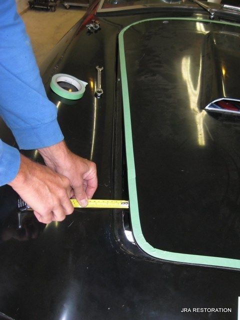 A person measuring a piece of tape on a black surface