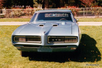 A gto car is parked in a grassy field