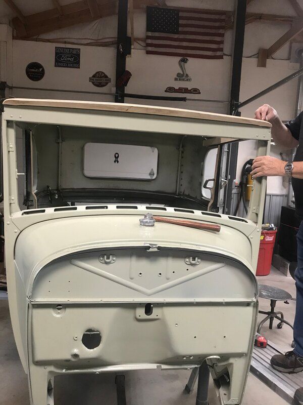 A man is working on a car in a garage.