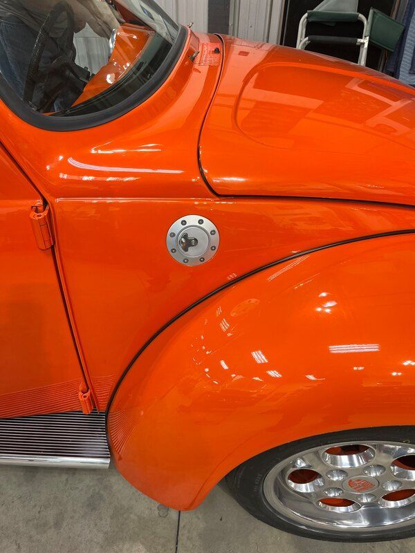 A close up of an orange car with a gas cap