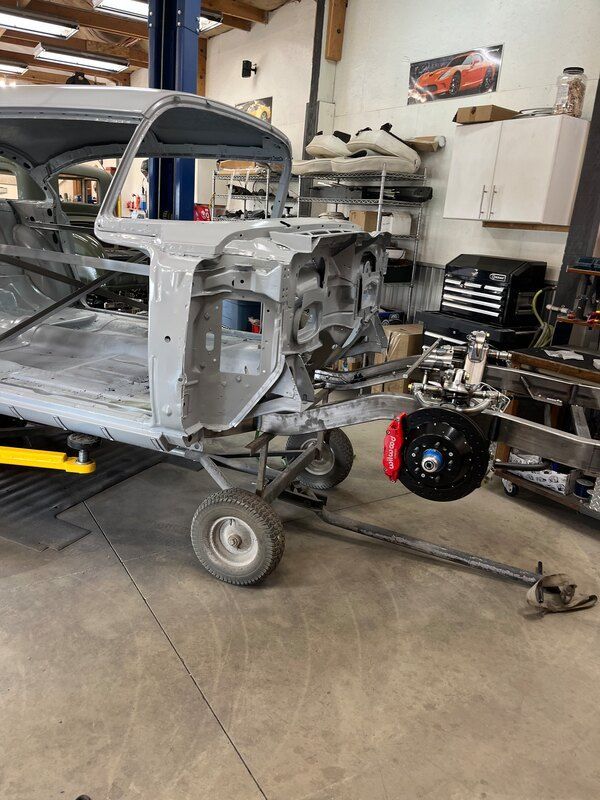 A car is sitting on a lift in a garage.