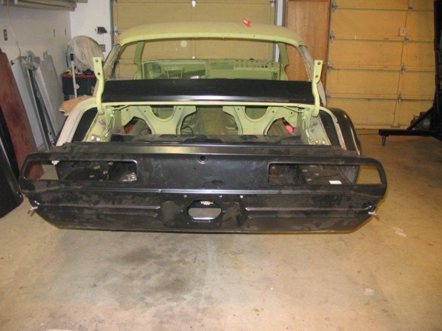 A green car is being built in a garage