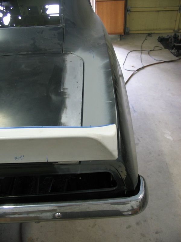 A black car with a white trim on the rear bumper