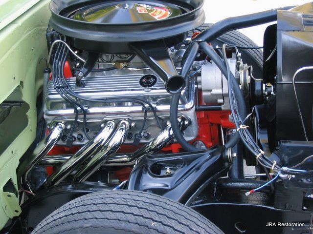 A close up of a car engine with a hood open