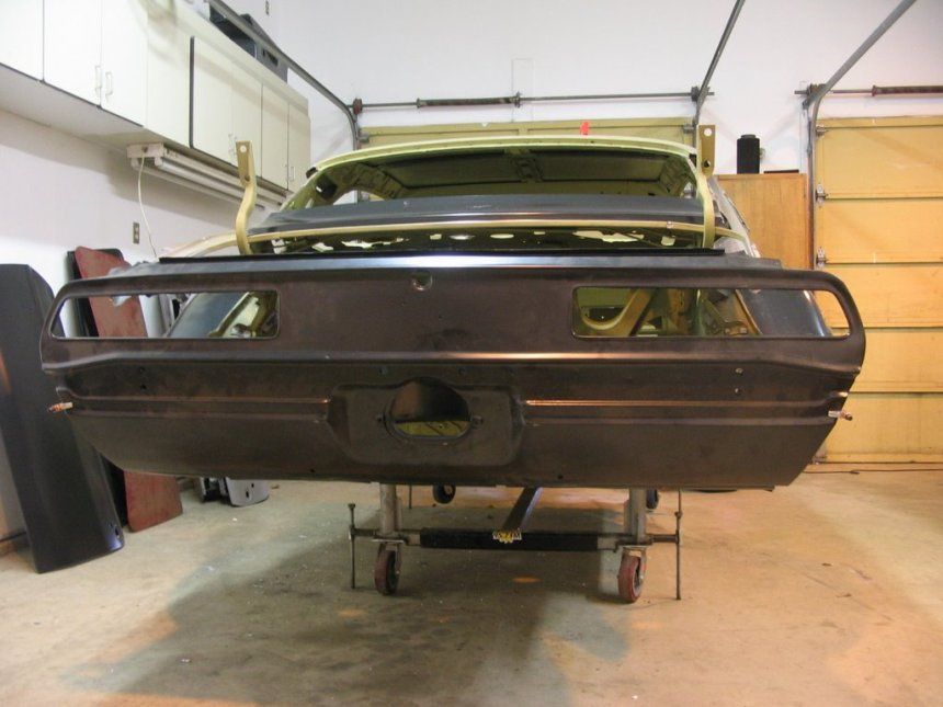 A car is sitting on a cart in a garage