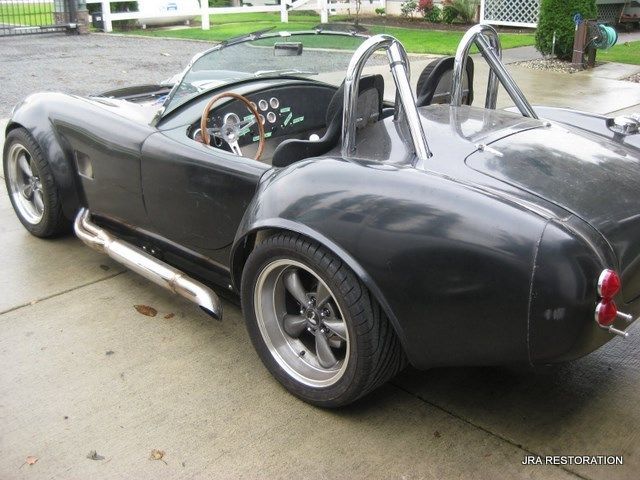 A black sports car is parked on the side of the road