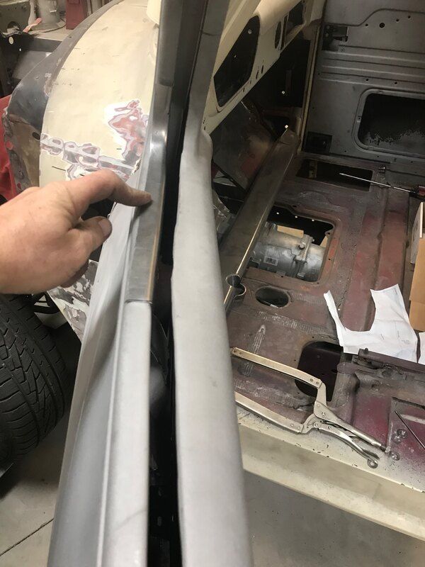 A person is working on a car in a garage.