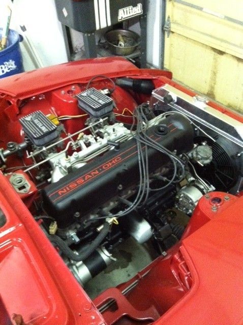 A red nissan engine is shown with the hood open