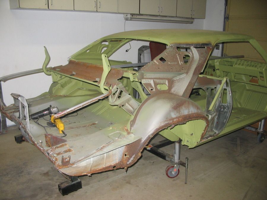 A green car is sitting on a cart in a garage