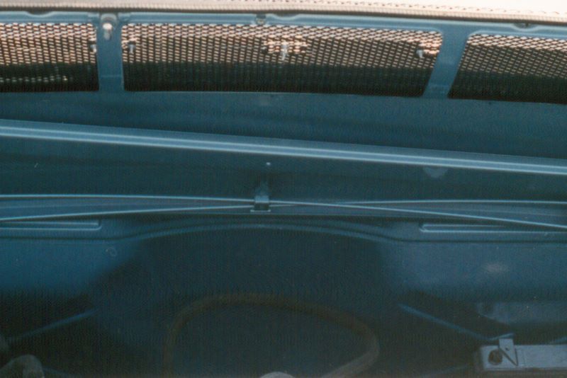 The hood of a blue car with a grille on it