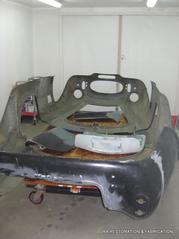 A black car is being built in a garage