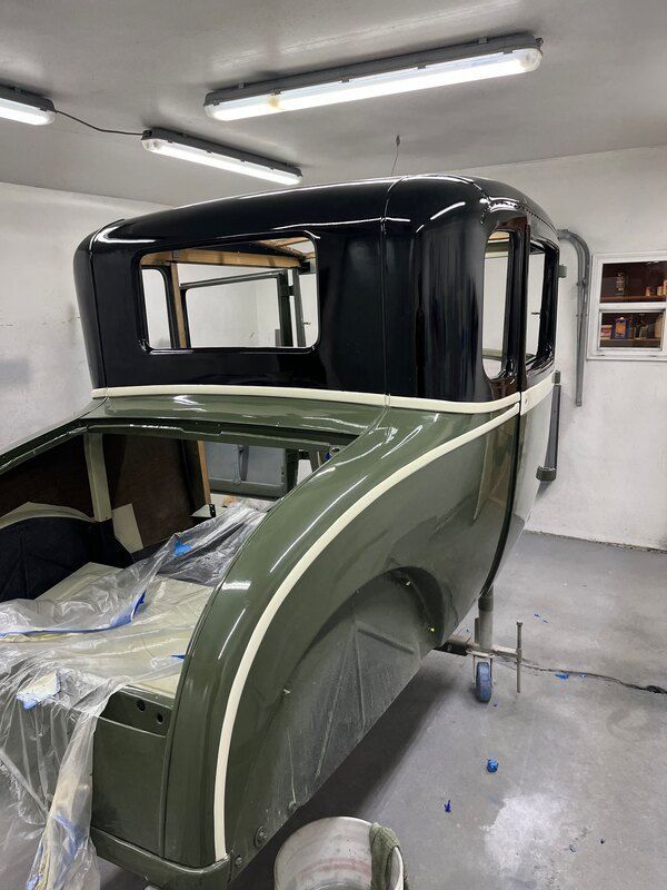 A car is being painted in a garage.