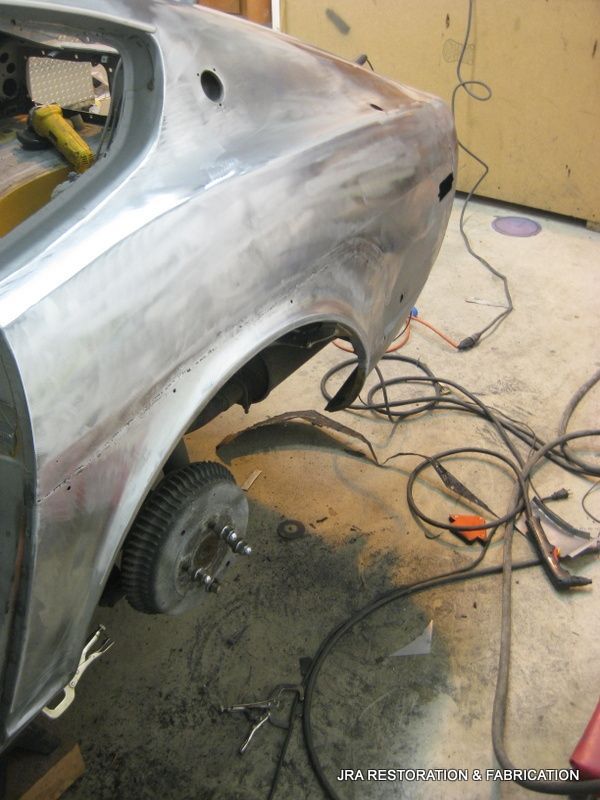 A silver car is being worked on in a garage