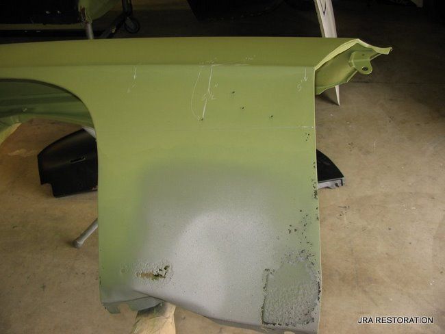 A green fender is sitting on a wooden table