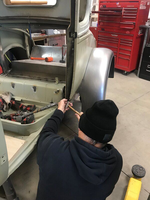 A man is working on a car in a garage