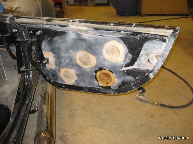 A car door is being repaired with holes in it