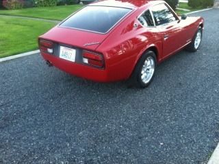 A red sports car is parked on the side of the road