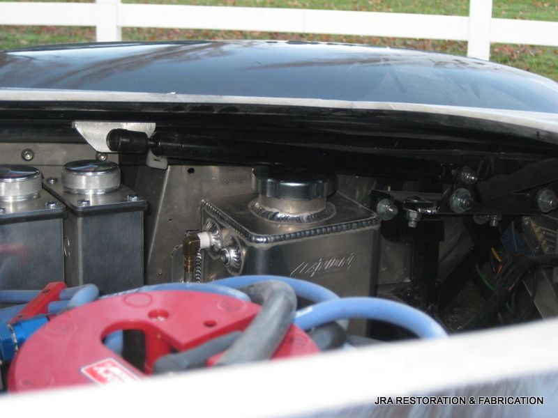 A close up of a car engine with a red fire extinguisher