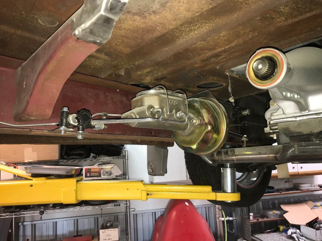 A car is sitting on a yellow lift in a garage.