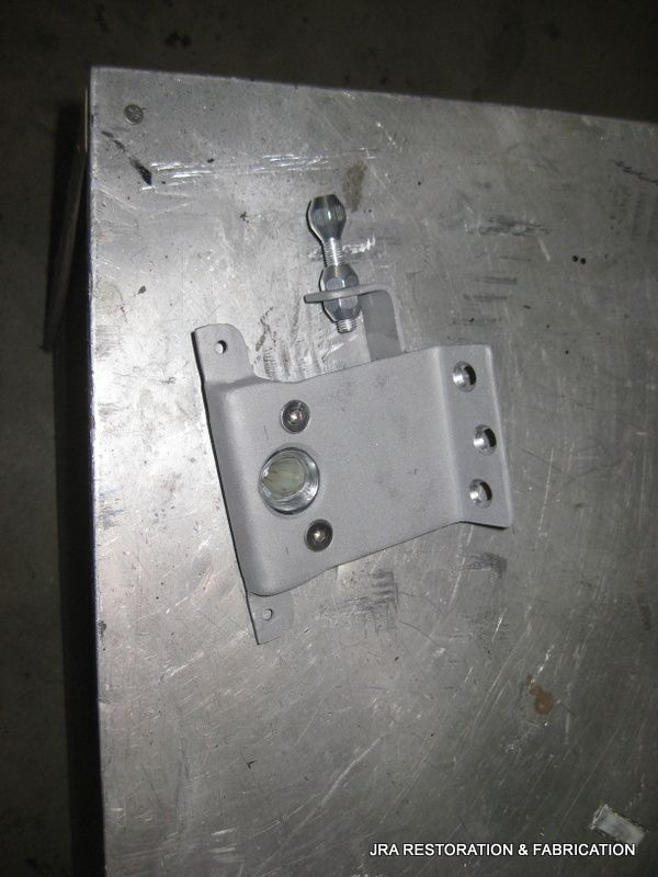 A piece of metal is sitting on a metal surface with the words jra restoration & fabrication on the bottom