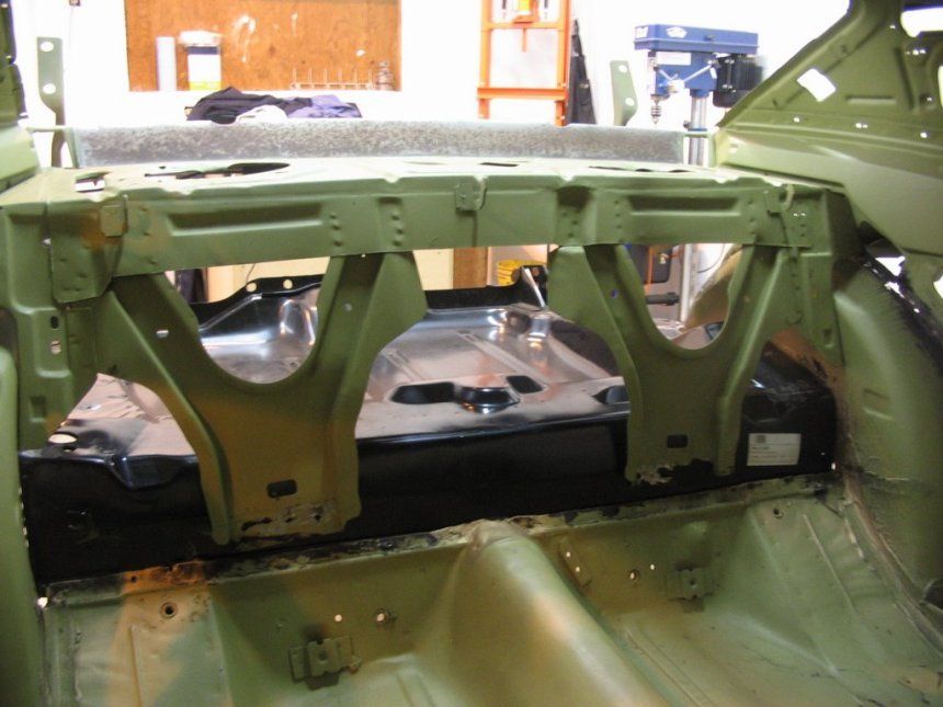 A green car is being worked on in a garage