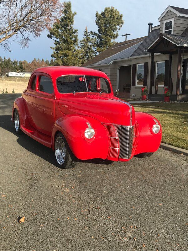 A red car is parked in front of a house