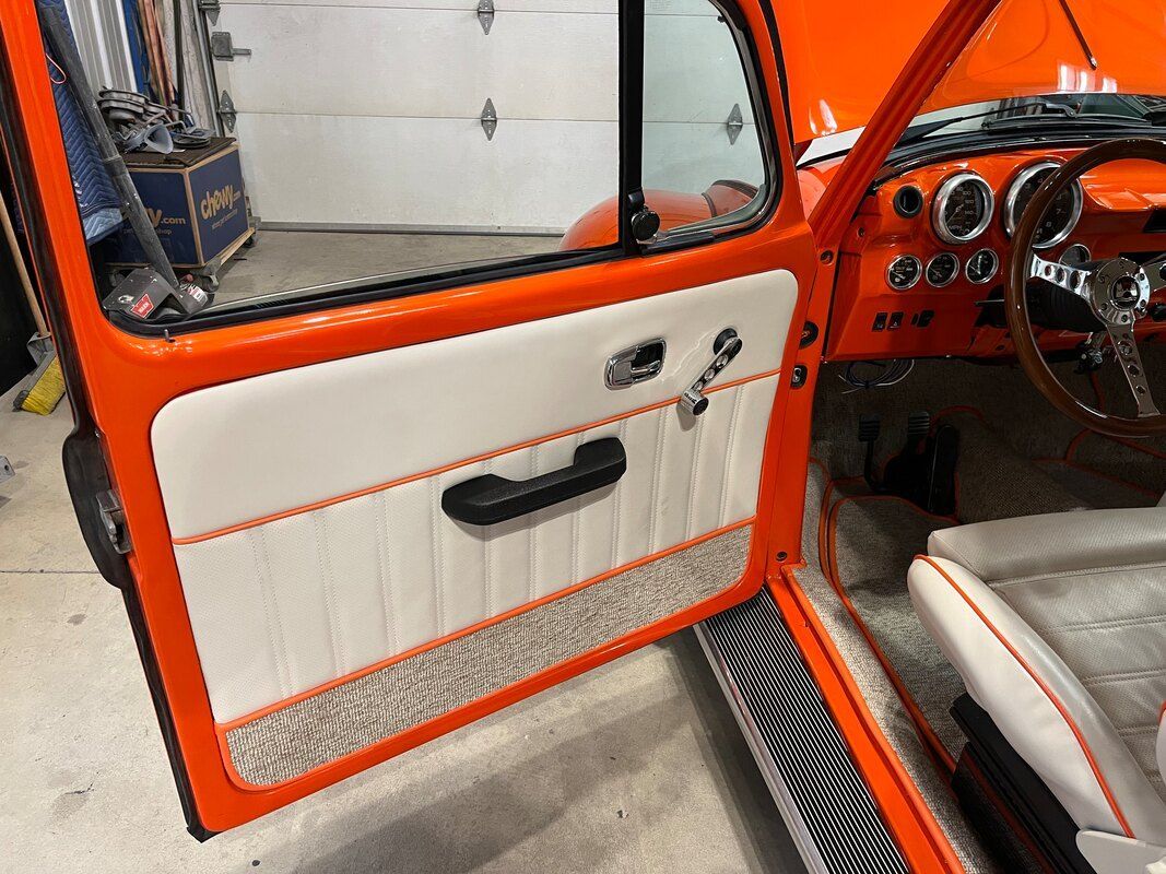 A close up of an orange car with the door open.
