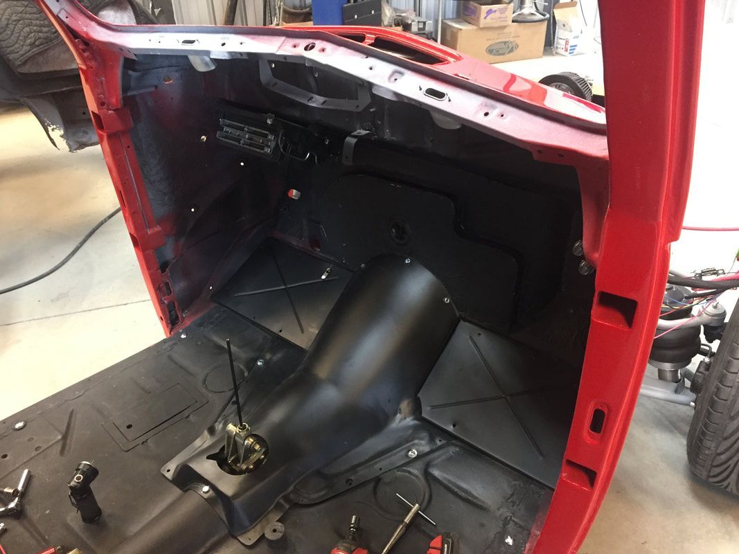 The inside of a red car is being worked on