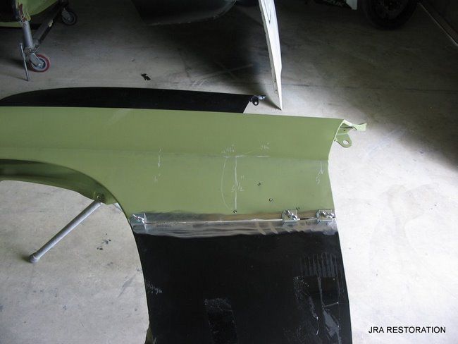 A green car fender is being repaired by jra restoration
