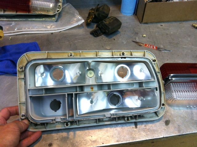 A person is holding a rear light that has the word ford on it