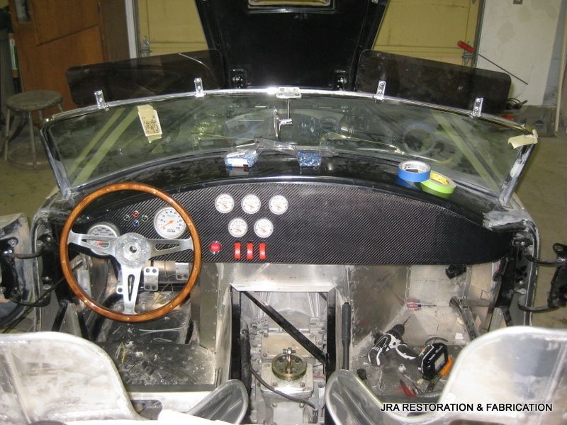 The inside of a car with the hood up and a steering wheel