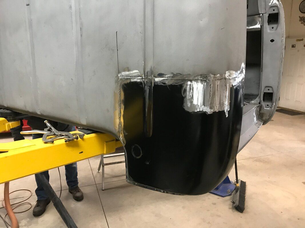 A person is working on a car in a garage.