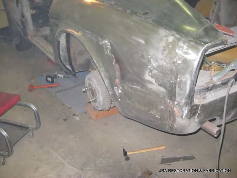 A fender of a car is being repaired in a garage