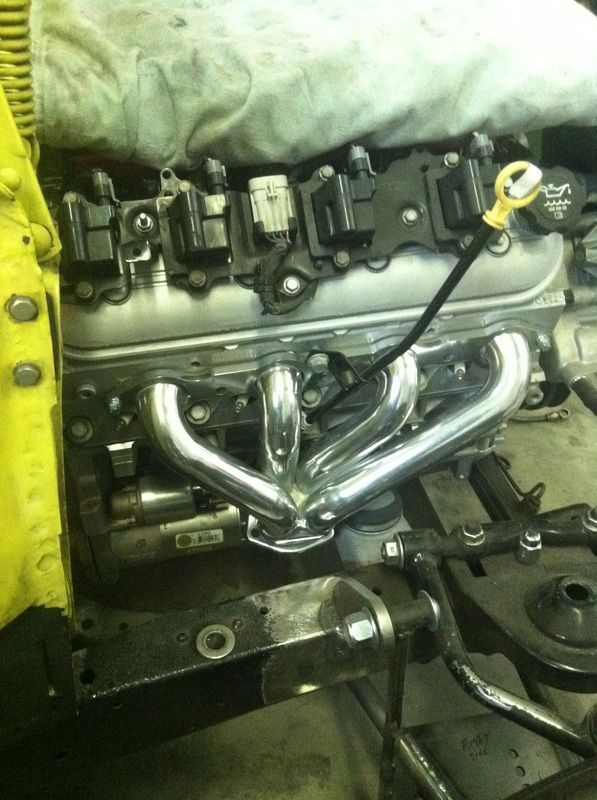 A close up of a car engine with a hose attached to it