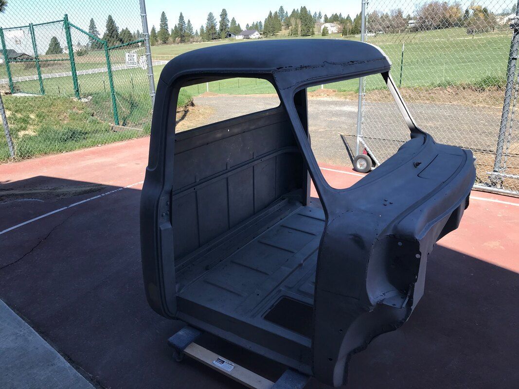 A truck body is sitting on top of a basketball court.
