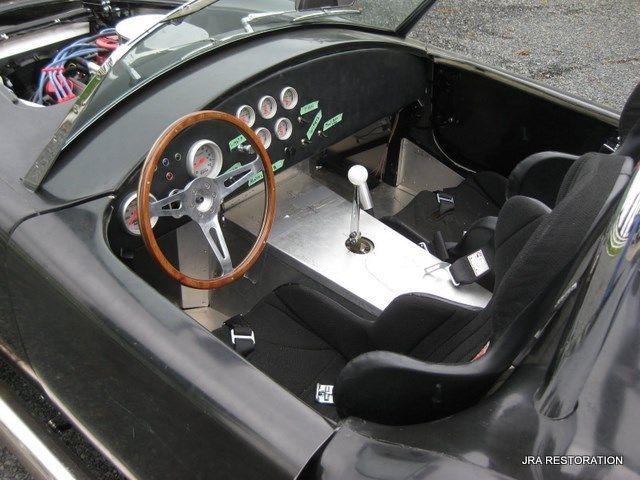 A black sports car with a wooden steering wheel