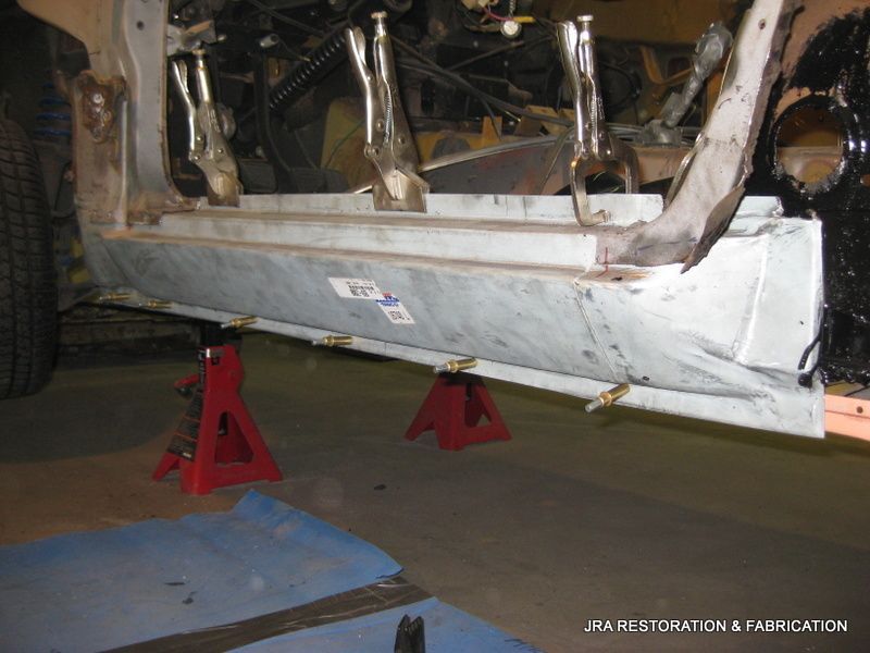 A piece of metal is sitting on a pair of red jack stands