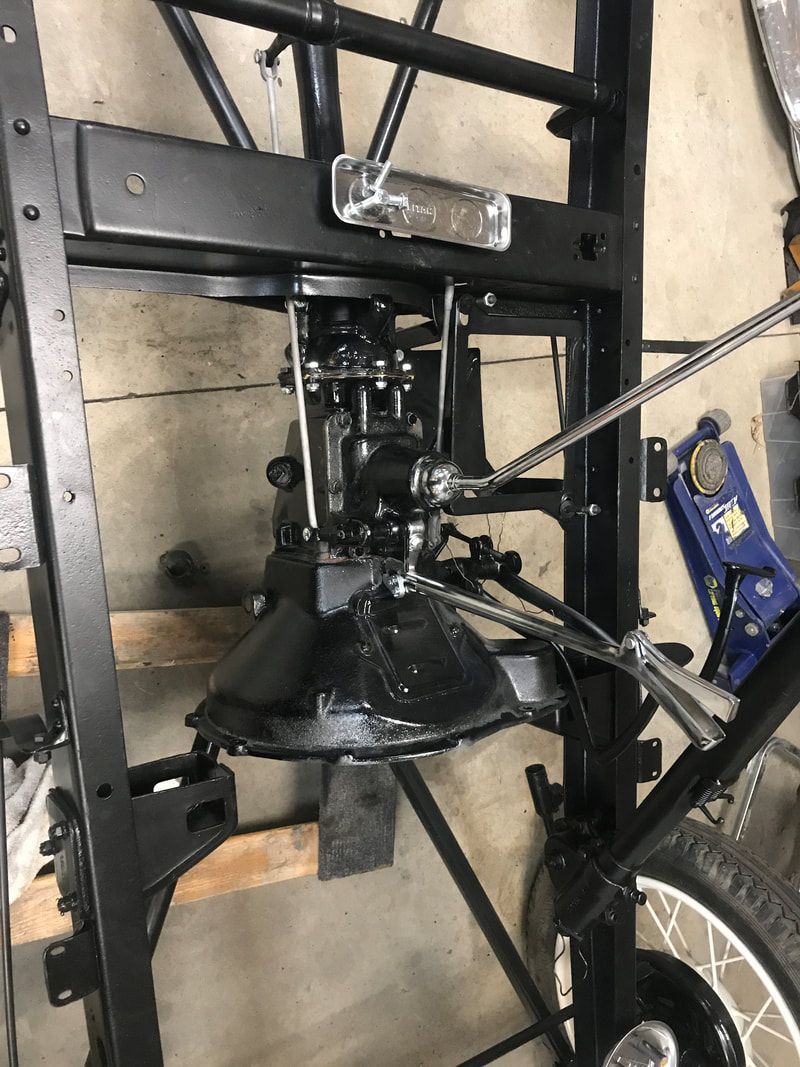 A black machine is sitting on top of a wooden table in a garage.
