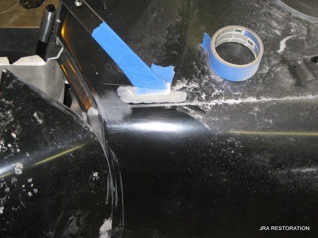 A piece of blue tape is laying on a black surface