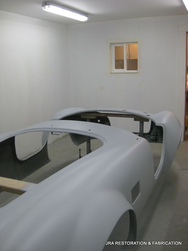 A picture of a car in a garage with the words jra restoration & fabrication on the bottom