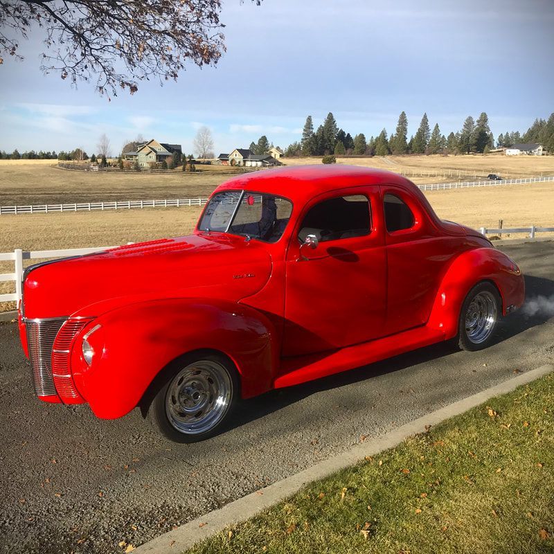 A red car is parked on the side of the road